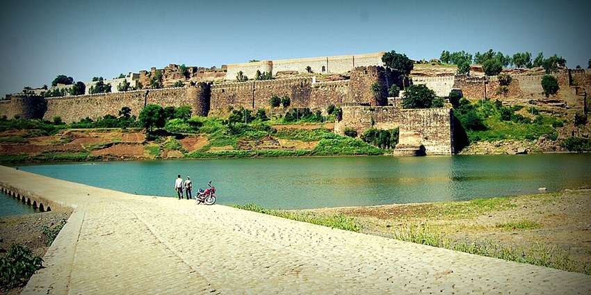 Tourists looking at the majesty of the Gagron fort from the lakeside.