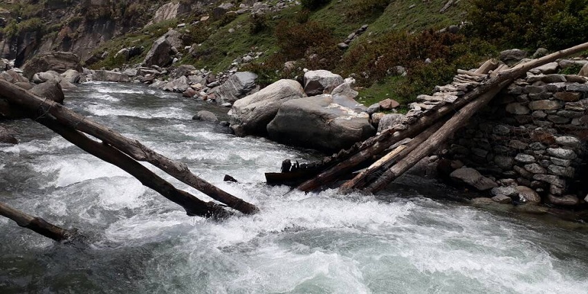 View of a beautiful stream rushing through the lush meadows of Hampta pass