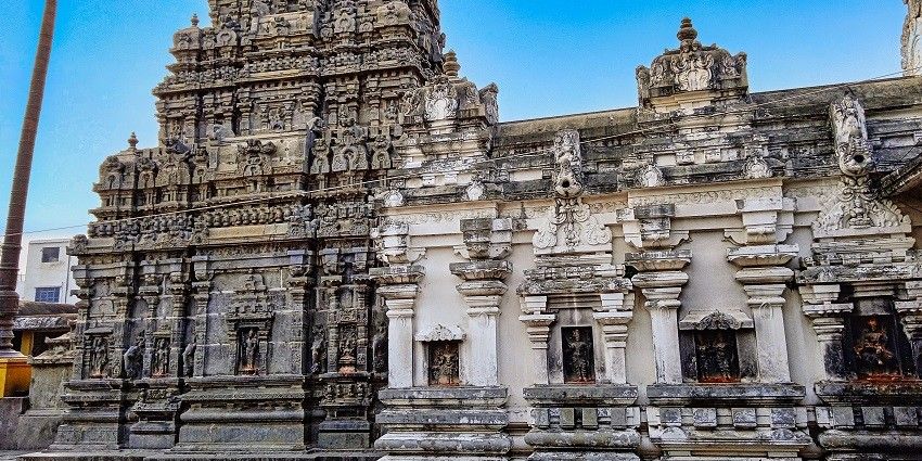 View of a sacred temple with intricately carved towers, surrounded and ancient stone pathways
