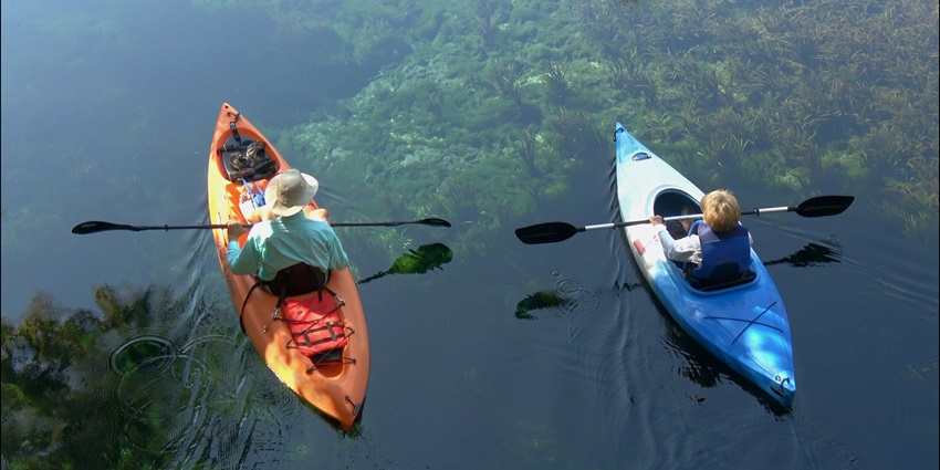 The view of the lake in Mysore Adventure Park with people kayaking on its azure waters.