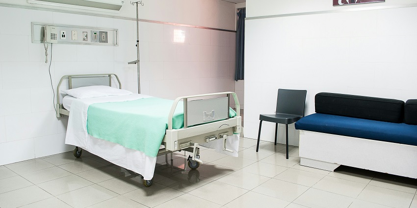 An inside view of the PGI Hospital featuring a patient bed and flickering lights.
