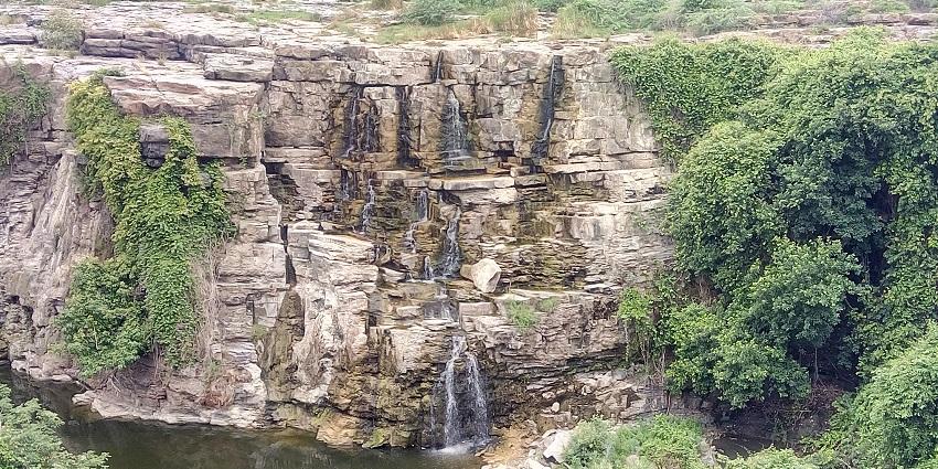 An aerial picture of a waterfall in Visakhapatnam cascading down a rocky hill