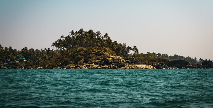 A glimpse of turquoise blue waters and an island decked with dense forests in Goa.