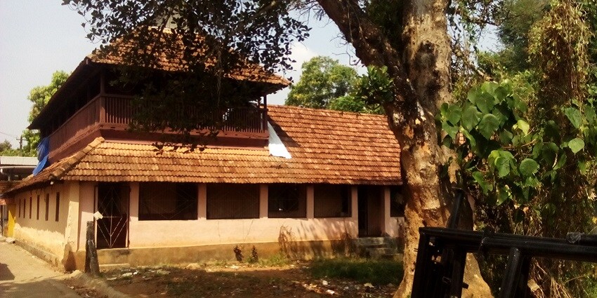 Pandalam Palace's elegant architecture surrounded by lush greenery in Kerala, India.