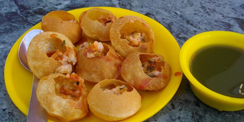 Pani Puri, a tangy flavoured snack, is being served at a busy street stall.