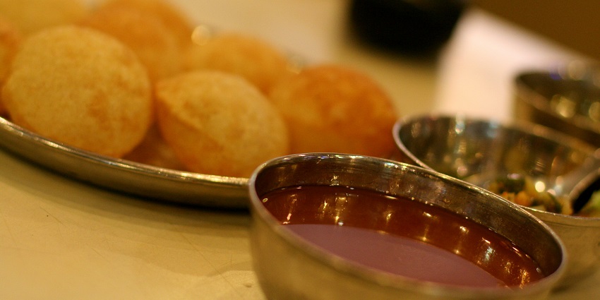 Pani Puri, popular street food in Vadodara, served with tamarind water.