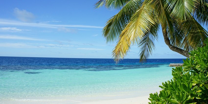 A beach with clear blue water glimmering under bright sun in the beautiful Malaysia.