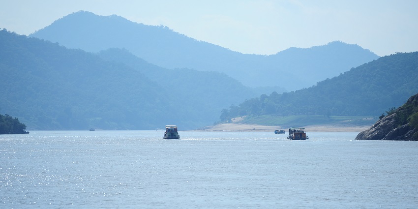 Serene river flowing through the lush Papi Hills which is a beautiful places to visit near temple