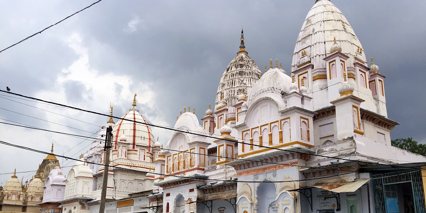 Serene white Papora Jain Temple under a cloudy sky, showcasing its tranquil beauty