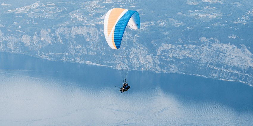 Paraglider soaring high above Pokhara with views of the Annapurna Range during the day.