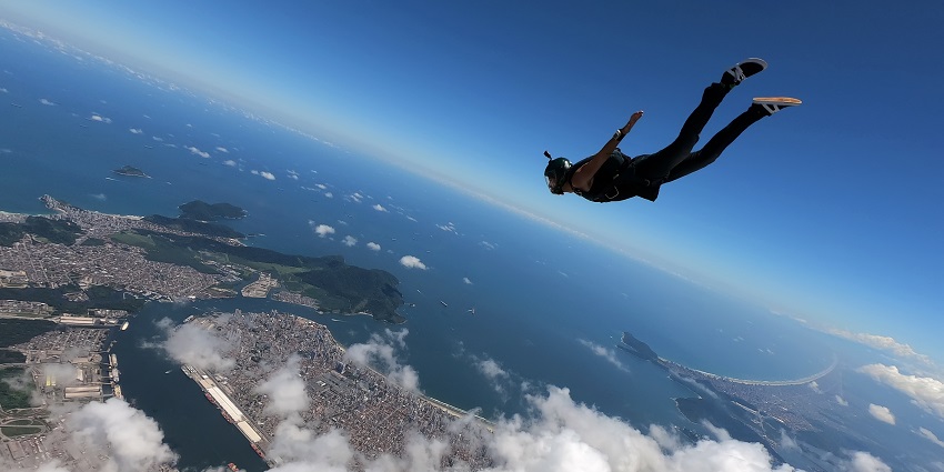 View of a man falling from the clear blue sky with clouds all around him