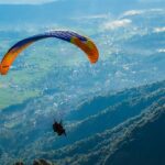 A view of a person soaring through the majestic peak high in the air in Himachal Pradesh.