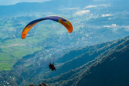 A view of a person soaring through the majestic peak high in the air in Himachal Pradesh.