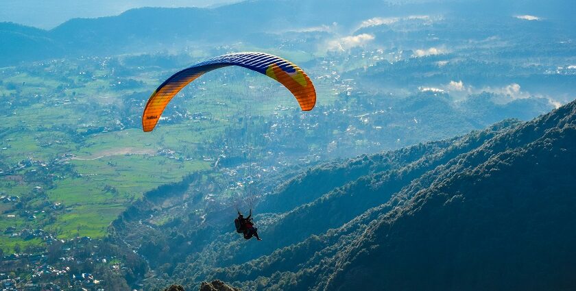 A view of a person soaring through the majestic peak high in the air in Himachal Pradesh.