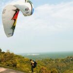 An image of a person paragliding in Dalhousie and the mesmerising views behind it.