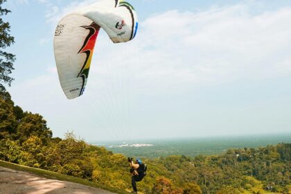 An image of a person paragliding in Dalhousie and the mesmerising views behind it.