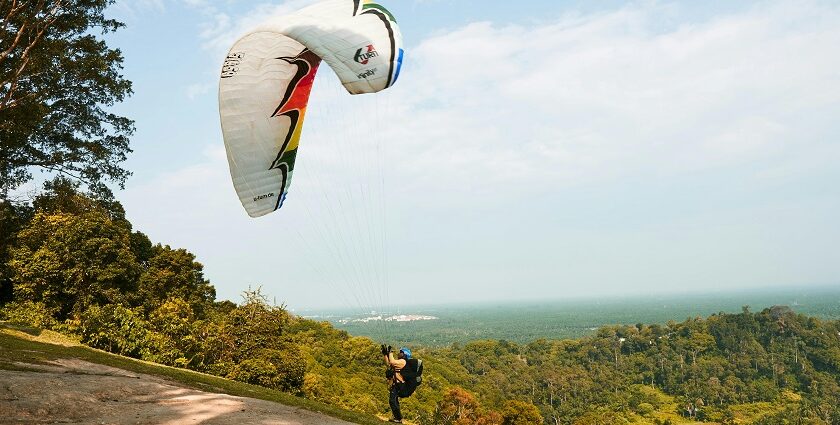 An image of a person paragliding in Dalhousie and the mesmerising views behind it.