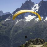 A man in a yellow parachute enjoying the mesmerising natural beauty from the above.