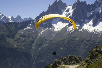 A man in a yellow parachute enjoying the mesmerising natural beauty from the above.