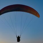 Tandem paraglider soaring over Vizag’s coastal landscape with stunning ocean views.