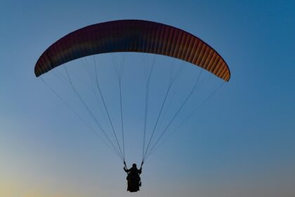 Tandem paraglider soaring over Vizag’s coastal landscape with stunning ocean views.