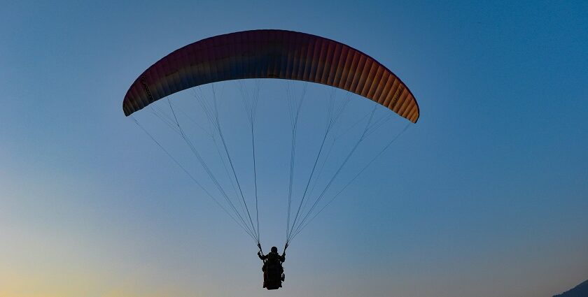 Tandem paraglider soaring over Vizag’s coastal landscape with stunning ocean views.