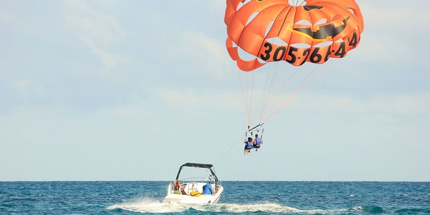 A picture showing a person enjoying the parasailing water sports at the Candolim beach