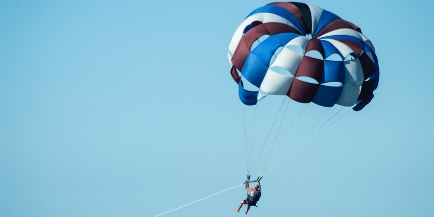 Parasailing is an adventure sport with a parachute ride over the sea, offering thrilling views.