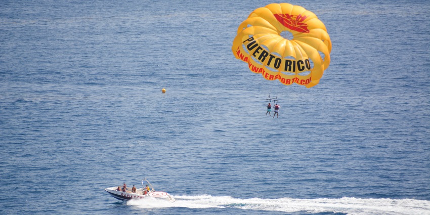 People enjoying parasailing in the sky.