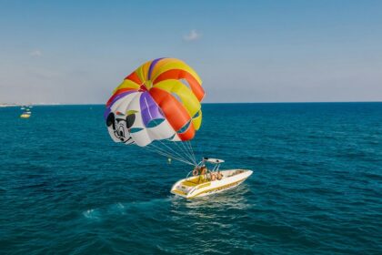 A mindblowing view of a motorboat attached to a parachute for an adventurous activity.