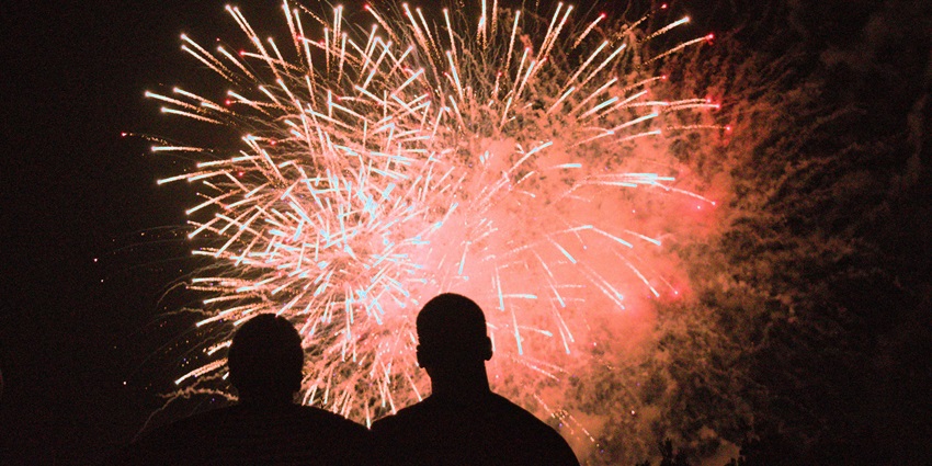 A breathtaking view of a couple enjoying colourful fireworks during the nighttime.