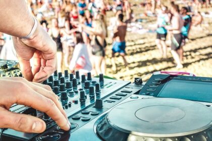 An image of a beach party scene at Vagator Beach in Goa with DJs and colourful lights.