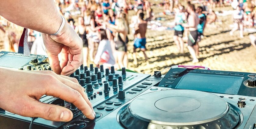 An image of a beach party scene at Vagator Beach in Goa with DJs and colourful lights.