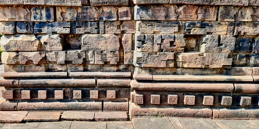 A picture of the temple's bricks, weathered by the passage of time, showing signs of erosion and a distinct, aged appearance.