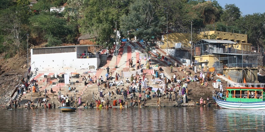 Devotees gathering at the serene Patalganga Ghat near Srisailam, with steps leading down to the river