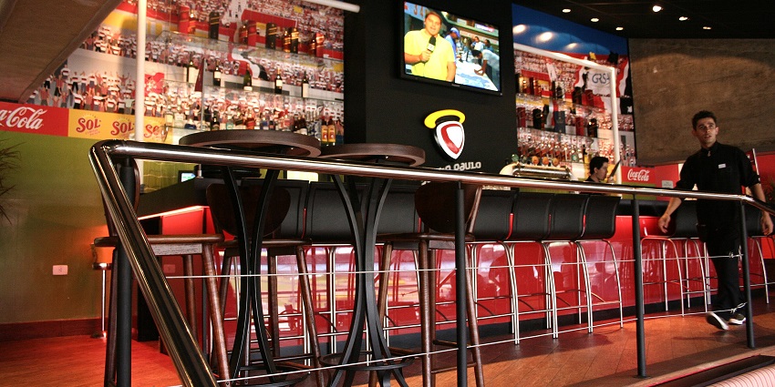 Vibrant view inside the Paulo's bar with a sports match playing on the screen
