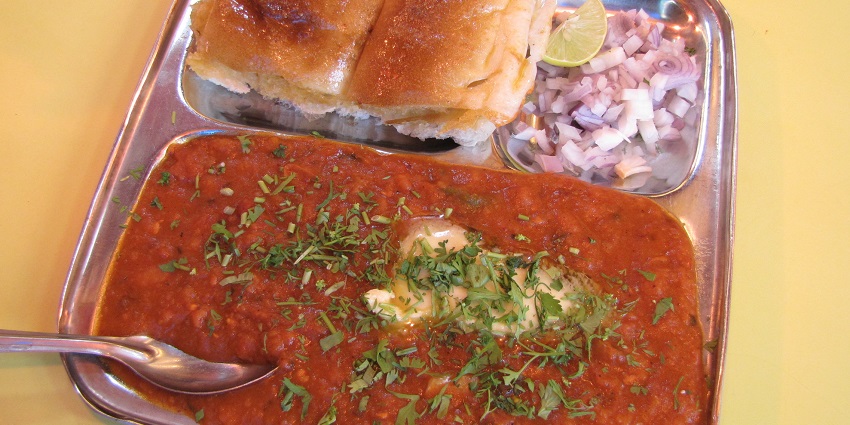 Pav bhaji is an authentic Mumbai snack served with lemon and onions on the side