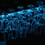 An image of glasses hanging upside down at a bar section of some restaurant.