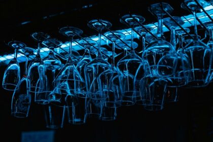 An image of glasses hanging upside down at a bar section of some restaurant.