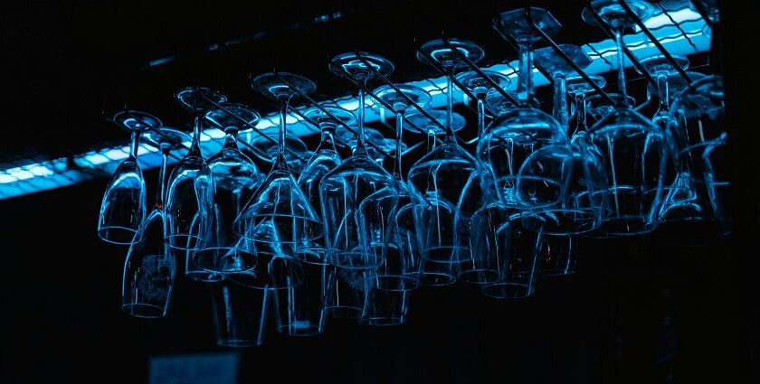 An image of glasses hanging upside down at a bar section of some restaurant.