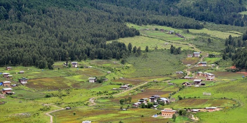 View of Phobjikha Valley, Bhutan, with traditional architecture and surrounding natural beauty.