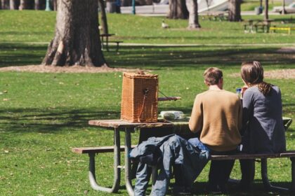 Image of a couple sitting on bench with picnic basket - one day picnic place near Ahmedabad