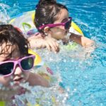 Two children splashing with joy in the resort pool, creating wonderful memories.