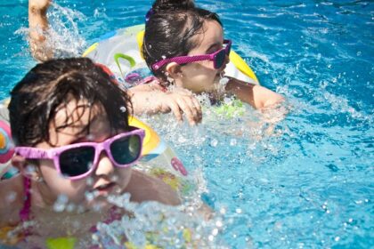 Two children splashing with joy in the resort pool, creating wonderful memories.