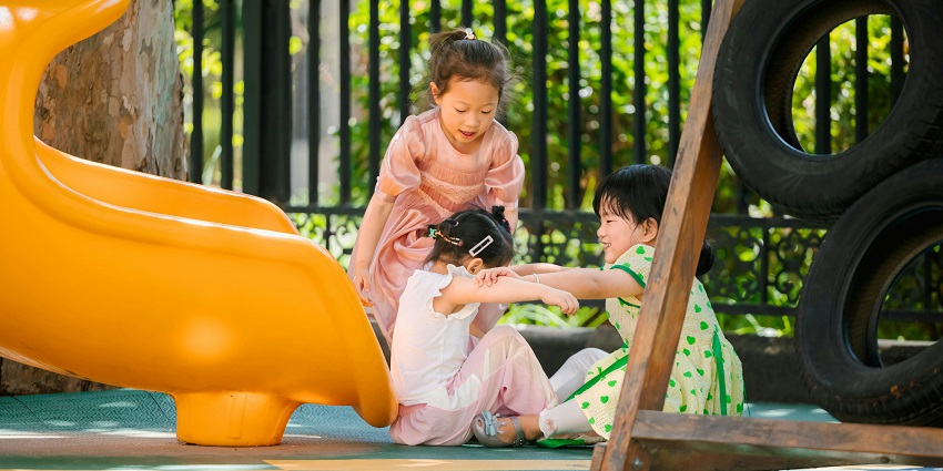 Children enjoying colourful water slides, making a splash in the bright pool.