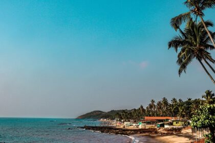 A scenic vista of cobalt-blue waters and golden sands decked with small houses and trees.