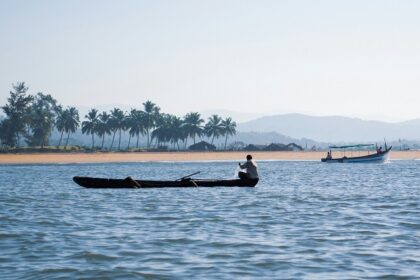 A view of the glistening waters of Goa decked with boats against a picturesque backdrop.