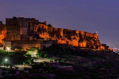 A serene glimpse of a palace brimming with yellow lights after the sun has set down.