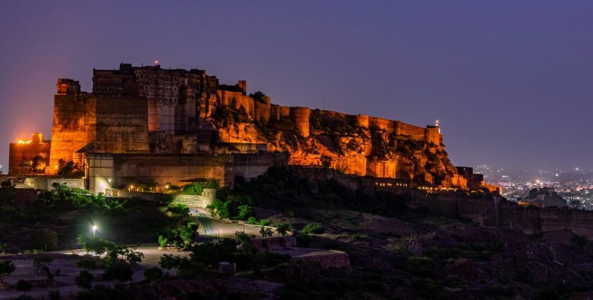 A serene glimpse of a palace brimming with yellow lights after the sun has set down.