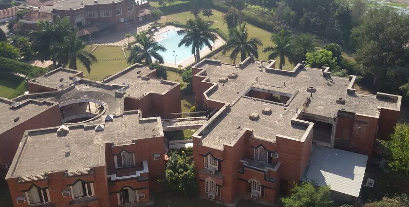 An aerial picture of a hotel in Panchkula with a garden and swimming pool in front